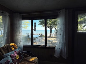 A room with a view of a deck and the sea.