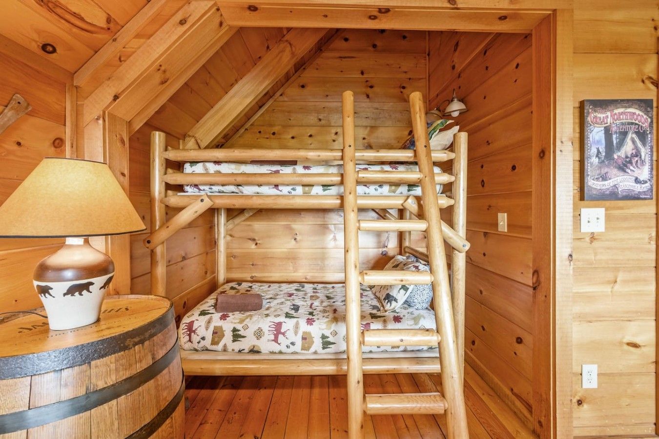 Un lit superposé en bois avec une échelle, une lampe et une affiche accrochée au mur.