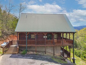 A wooden cabin with a porch, a staircase, and a metal roof. - Incredible MTN Views! Hot Tub*Game Room*Quiet*Pets (Sevierville)