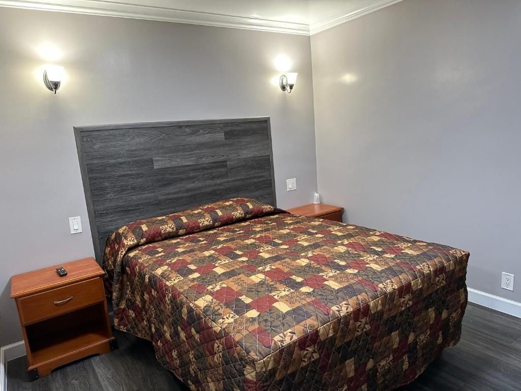 Un dormitorio con cama, mesitas de noche e iluminación empotrada.