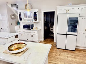 A kitchen with white cabinetry, a marble countertop, and a wooden floor. - Spacious 7-bedroom house with AC in wonderful Naperville (Naperville)