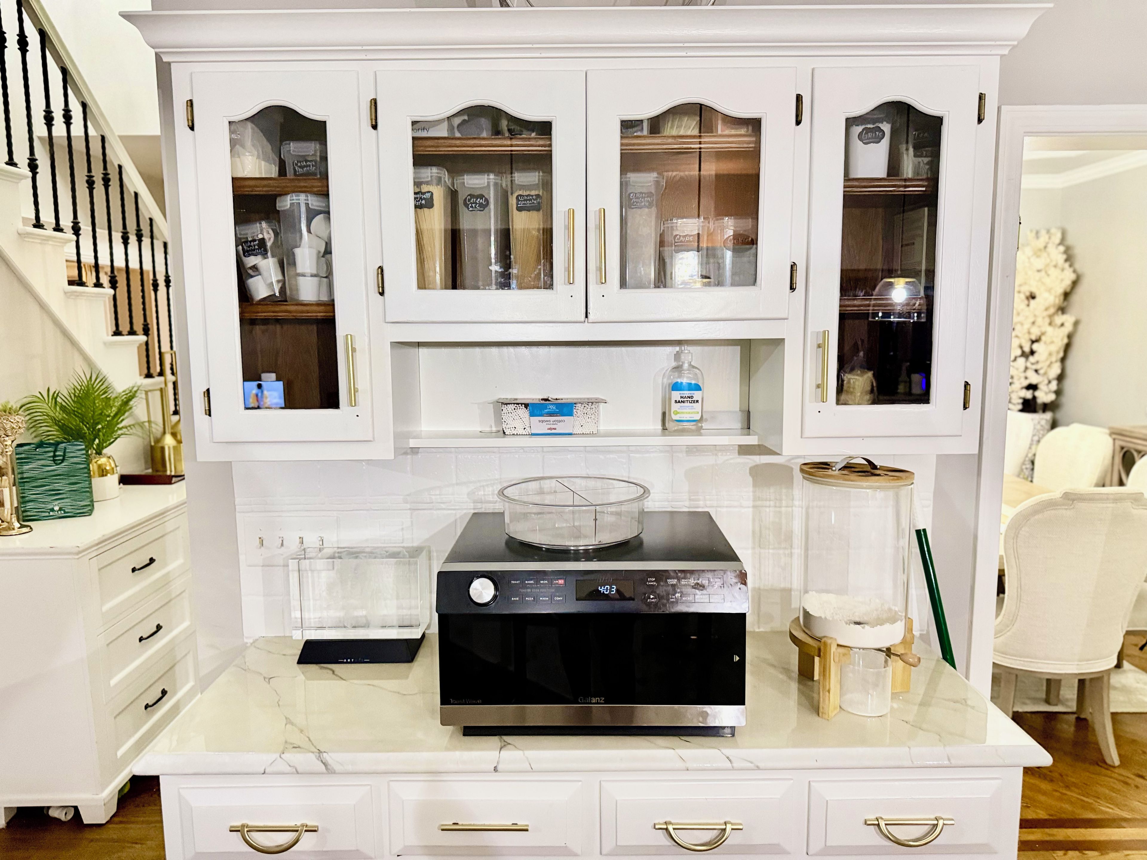 A kitchen with white cabinets, a black stove, and a marble countertop.