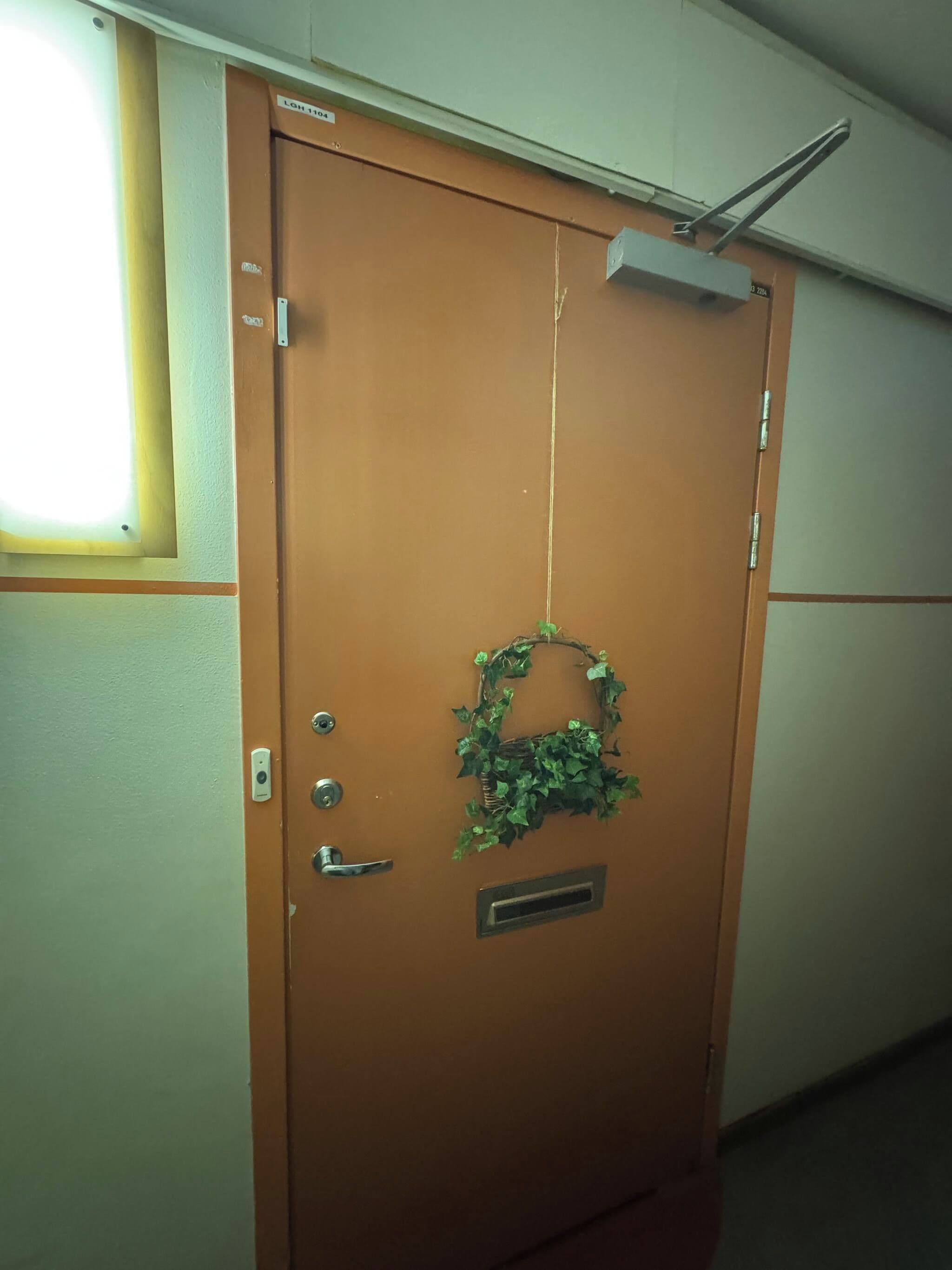 A brown door with a metal handle, a keyhole, and a small vent.