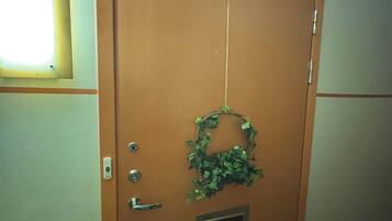 A brown door with a metal handle, a keyhole, and a small vent.