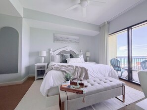 Ein Schlafzimmer mit einem Bett, Nachttischen, einer Bank und Blick ins Freie.