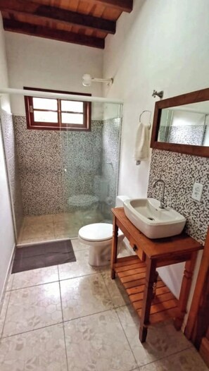 A bathroom with a shower, toilet, and sink. - Vacation home on Rua da Praia da Feiticeira. (Ilhabela)