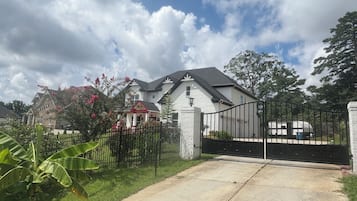 Una propiedad residencial cerrada con un camino de entrada que lleva a una casa.