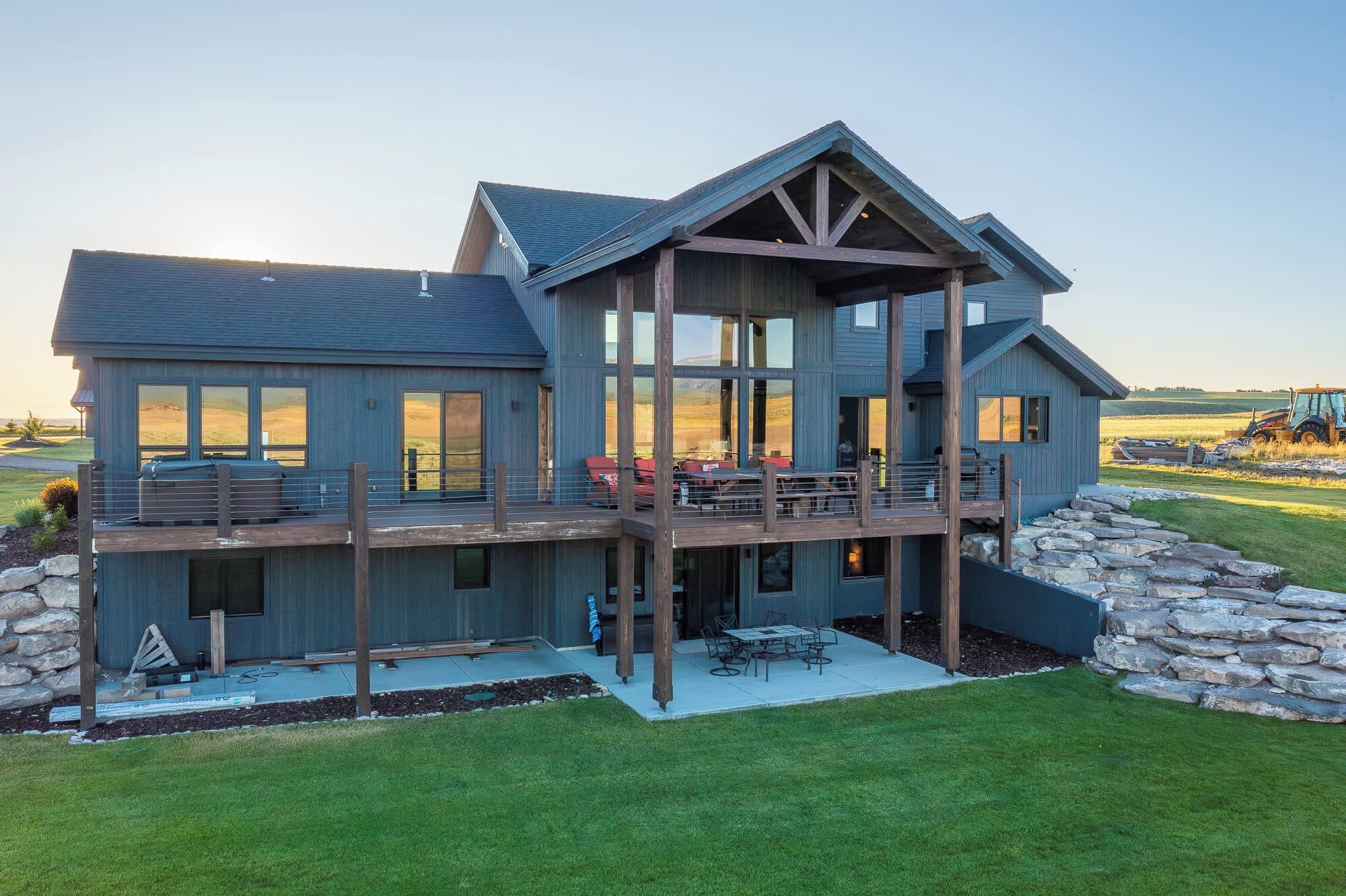 A large, two-story house with a balcony and a stone foundation.