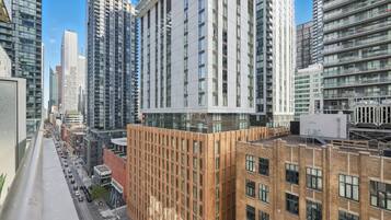 Un edificio moderno de gran altura con fachada de líneas verticales, rodeado de otros edificios altos.