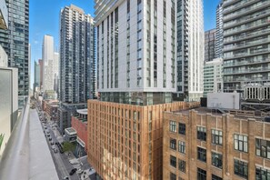 Un edificio moderno de gran altura con fachada de líneas verticales, rodeado de otros edificios altos.