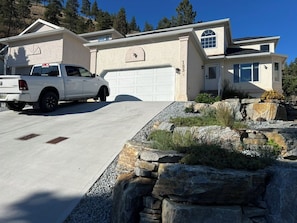 A residential property with a garage, a driveway, and a rock garden.