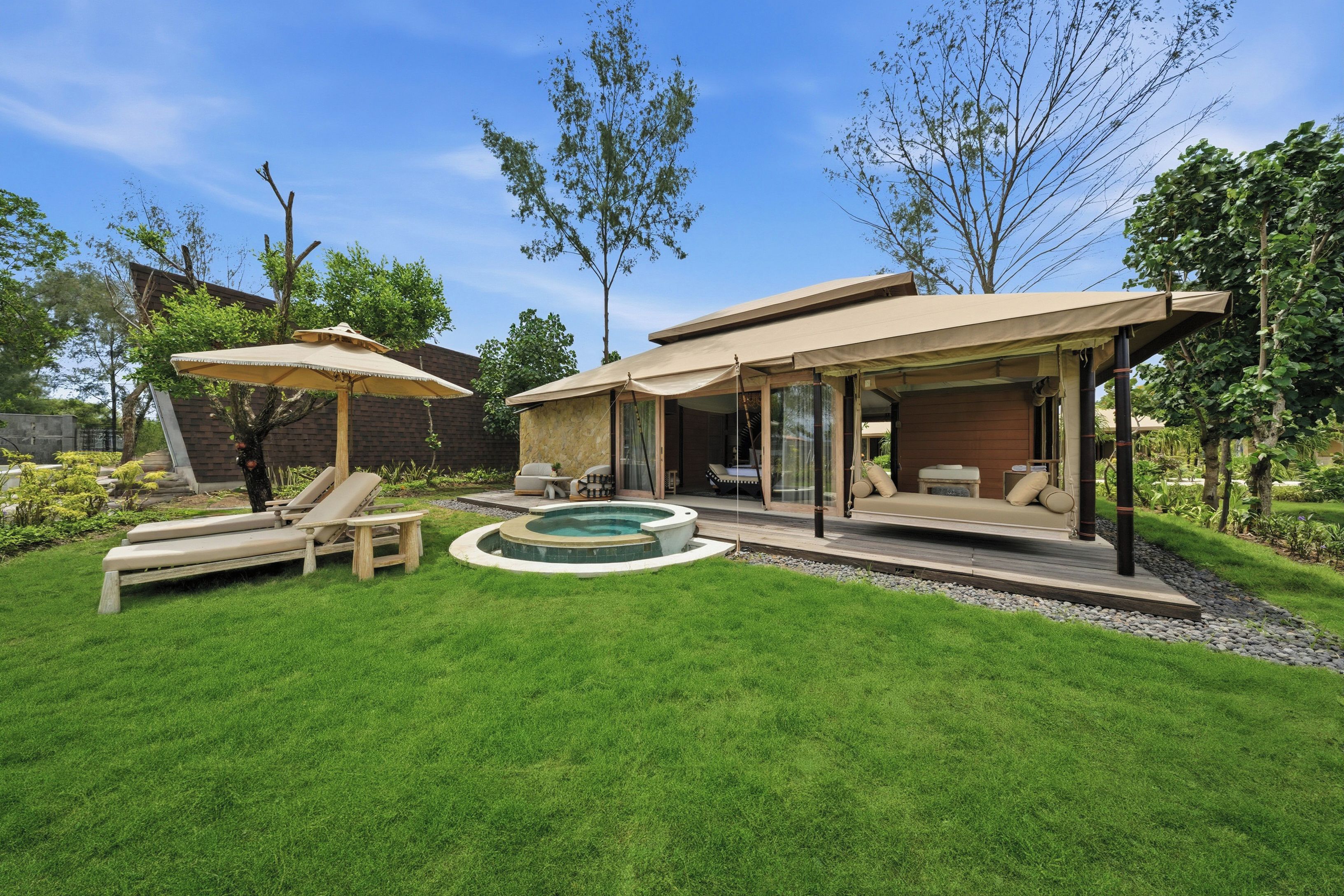 Ein Garten mit Swimmingpool, Liegestühlen und einer überdachten Terrasse.