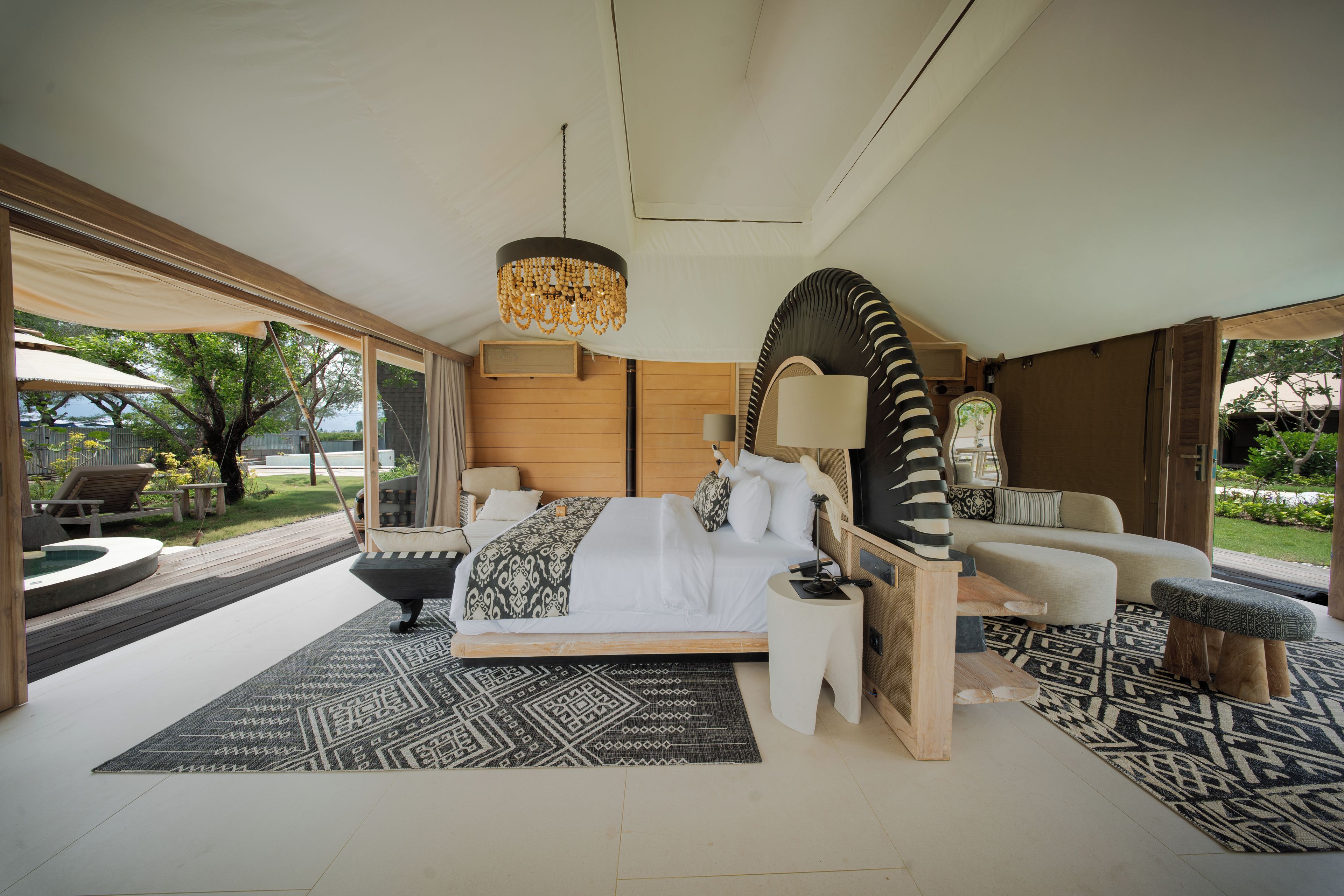 Een ruime slaapkamer met een groot bed, een zithoek en uitzicht op het groen.