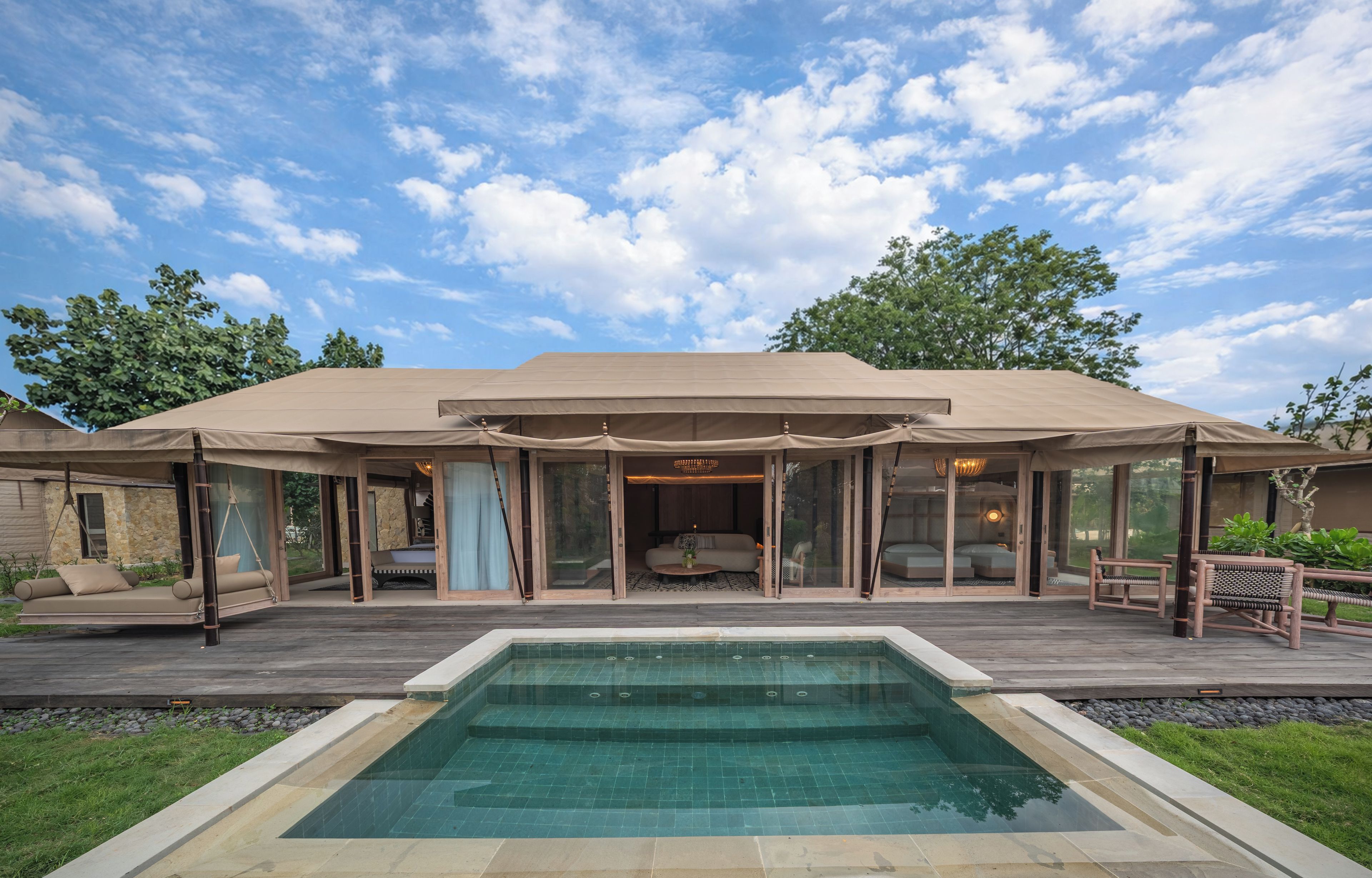 A modern house with a swimming pool, large windows, and a covered patio area.