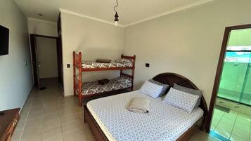 A bedroom with a single bed, a wooden bunk bed, and a small desk.