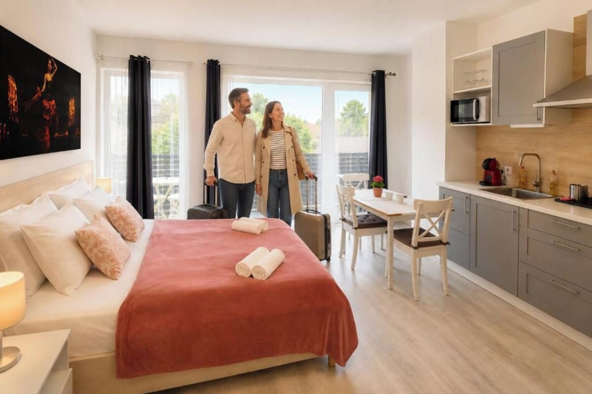 Une chambre d’hôtel moderne équipée d’un lit, d’un coin repas et d’une kitchenette.