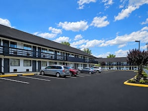 Un motel doté de nombreux espaces de stationnement et offrant une vue sur un ciel dégagé.