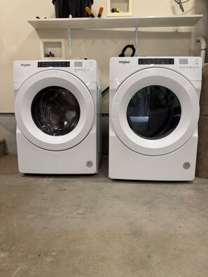 Dos lavadoras Whirlpool blancas de carga frontal, una al lado de la otra.