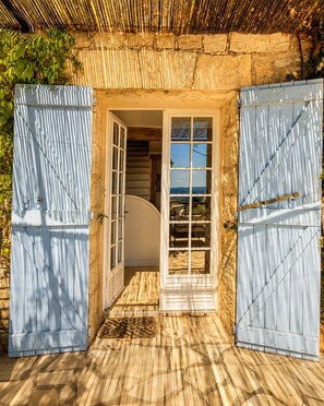 Une porte donnant sur un escalier en colimaçon menant à un balcon.