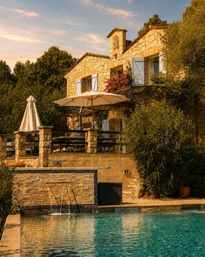 A stone building with a pool, outdoor seating, and a covered patio area. - L'Olivette de Callian - Provence Home with Panoramic View (Callian)