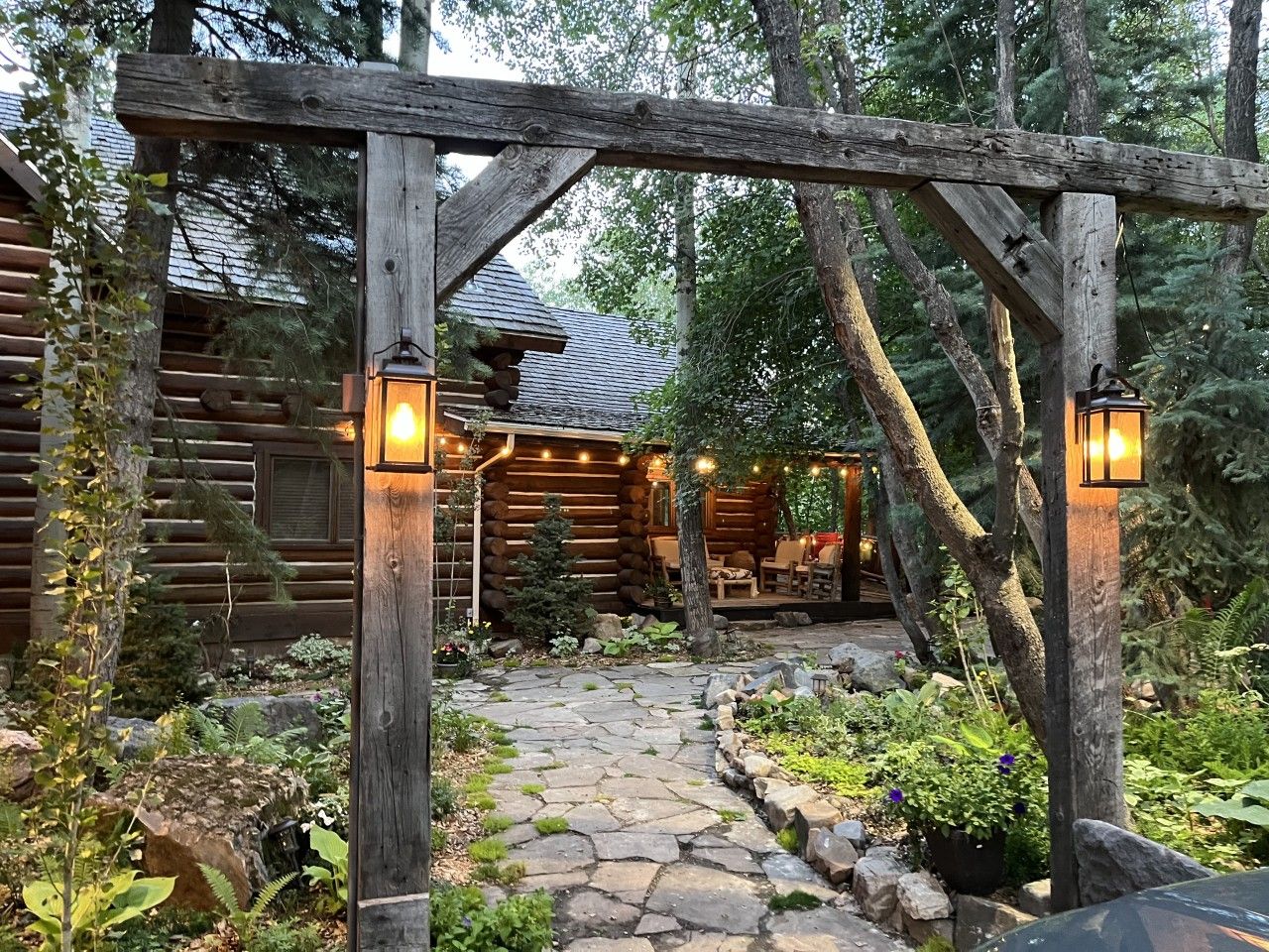 A log cabin with a stone pathway leading to a porch.
