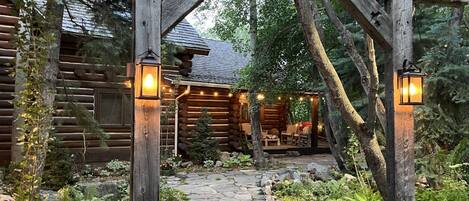 A log cabin with a stone pathway leading to a porch.