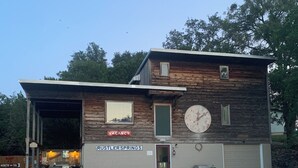 Ein zweistöckiges Gebäude mit einem 'VACANCY'-Schild, einer Garage und einem überdachten Außenbereich.