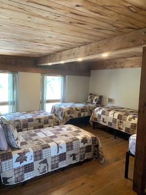 A room with two beds, wooden flooring, and a sloped ceiling. - Murt’s Lodge at Red Canoe Lodge Historic Lake Whitney Resort, Totaly Reimagined (Clifton)