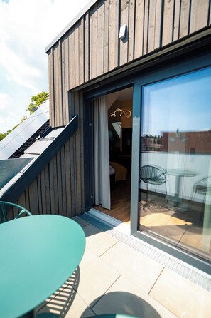 A modern building with a wooden facade, a glass door entrance, and a visible interior with a dining area. - Vrbo Property (Erbach)