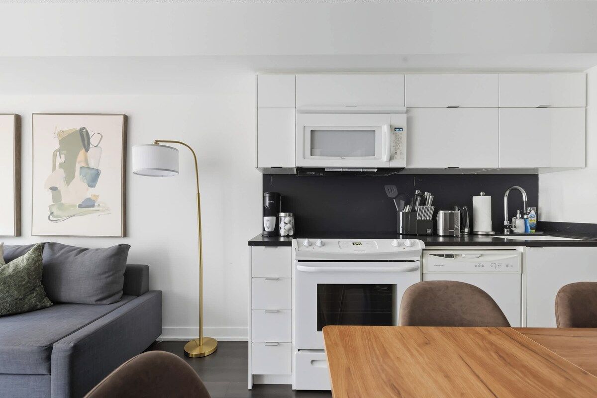 A modern kitchen with white cabinets, a microwave, a stove, and a dishwasher.