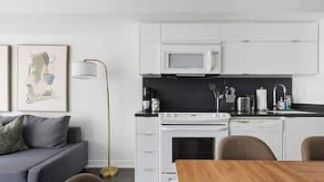 A modern kitchen with white cabinets, a microwave, a stove, and a dishwasher.