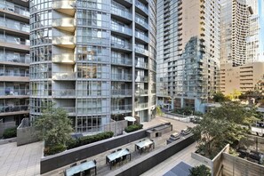Un immeuble moderne à plusieurs étages, doté de nombreux balcons, d’espaces de détente en plein air et d’une terrasse sur le toit.