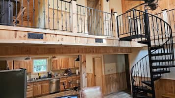 Um amplo loft com cozinha, sala de jantar e escada em espiral.
