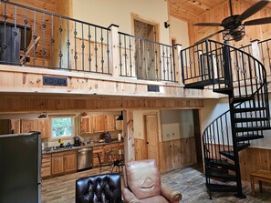 Um amplo loft com cozinha, sala de jantar e escada em espiral.