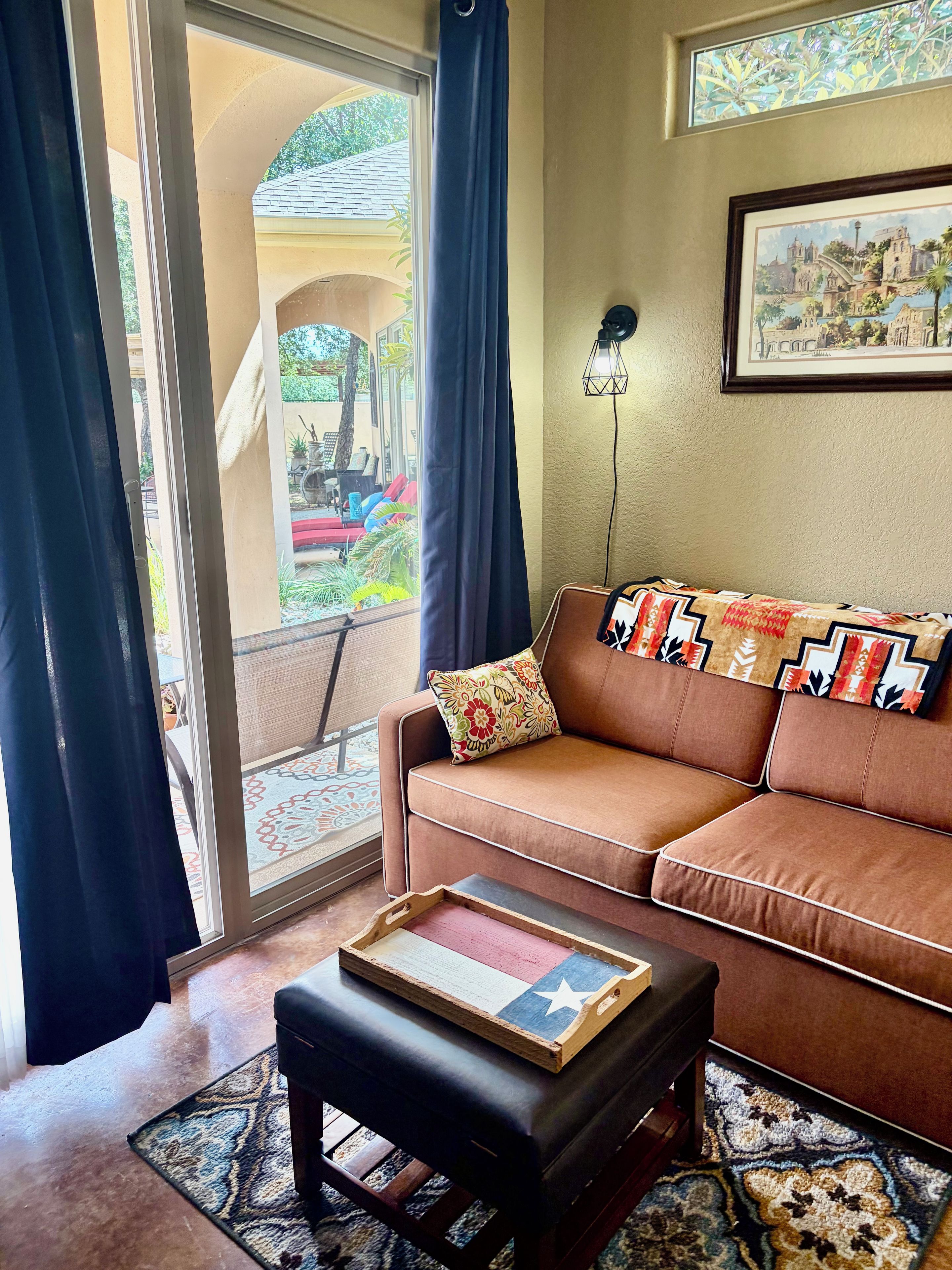 A living room with a brown sofa, a wooden coffee table, and a patterned rug.