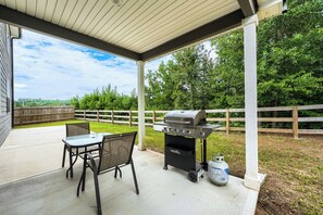 An outdoor patio with a grill, a table, and chairs. -     Stylish 4BR Home, Fenced Yard, Office + Tesla Charger (Dallas)
