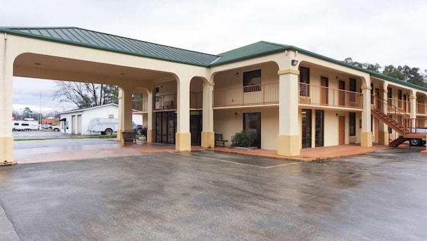 A two-story motel with a covered parking area and a staircase leading to the upper level. - Days Inn & Suites by Wyndham Brewton (Brewton)