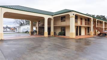A two-story motel with a covered parking area and a staircase leading to the upper level.