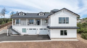 A two-story house with a balcony, a garage, and a driveway.