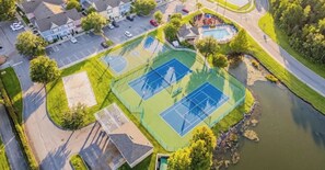 Eine Vogelperspektive eines Wohngebiets mit Basketballplatz, Schwimmbad und einer Straße.