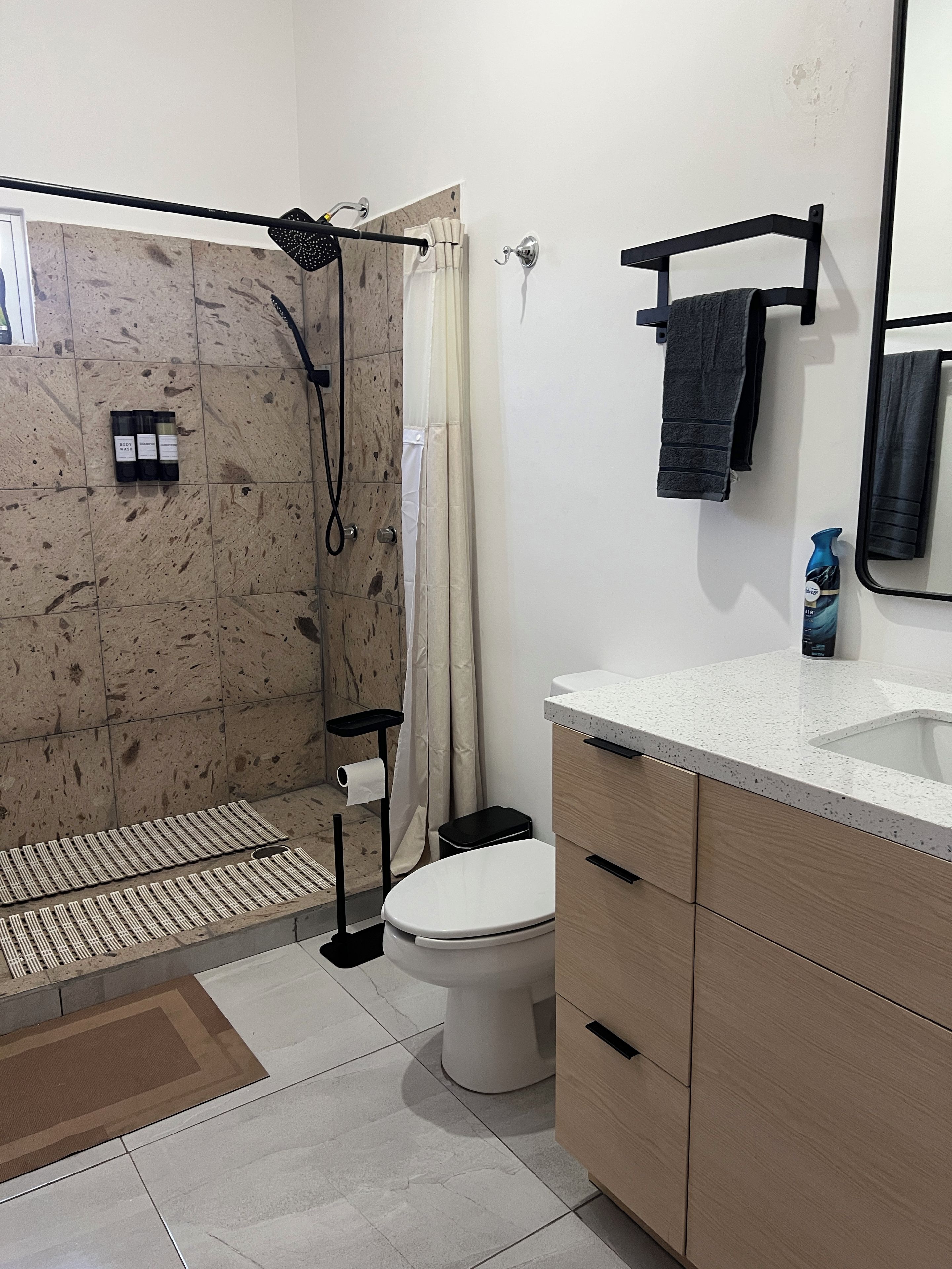 Ein Badezimmer mit Dusche, Toilette und Waschbecken.