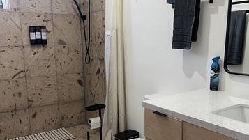 Ein Badezimmer mit Dusche, Toilette und Waschbecken.
