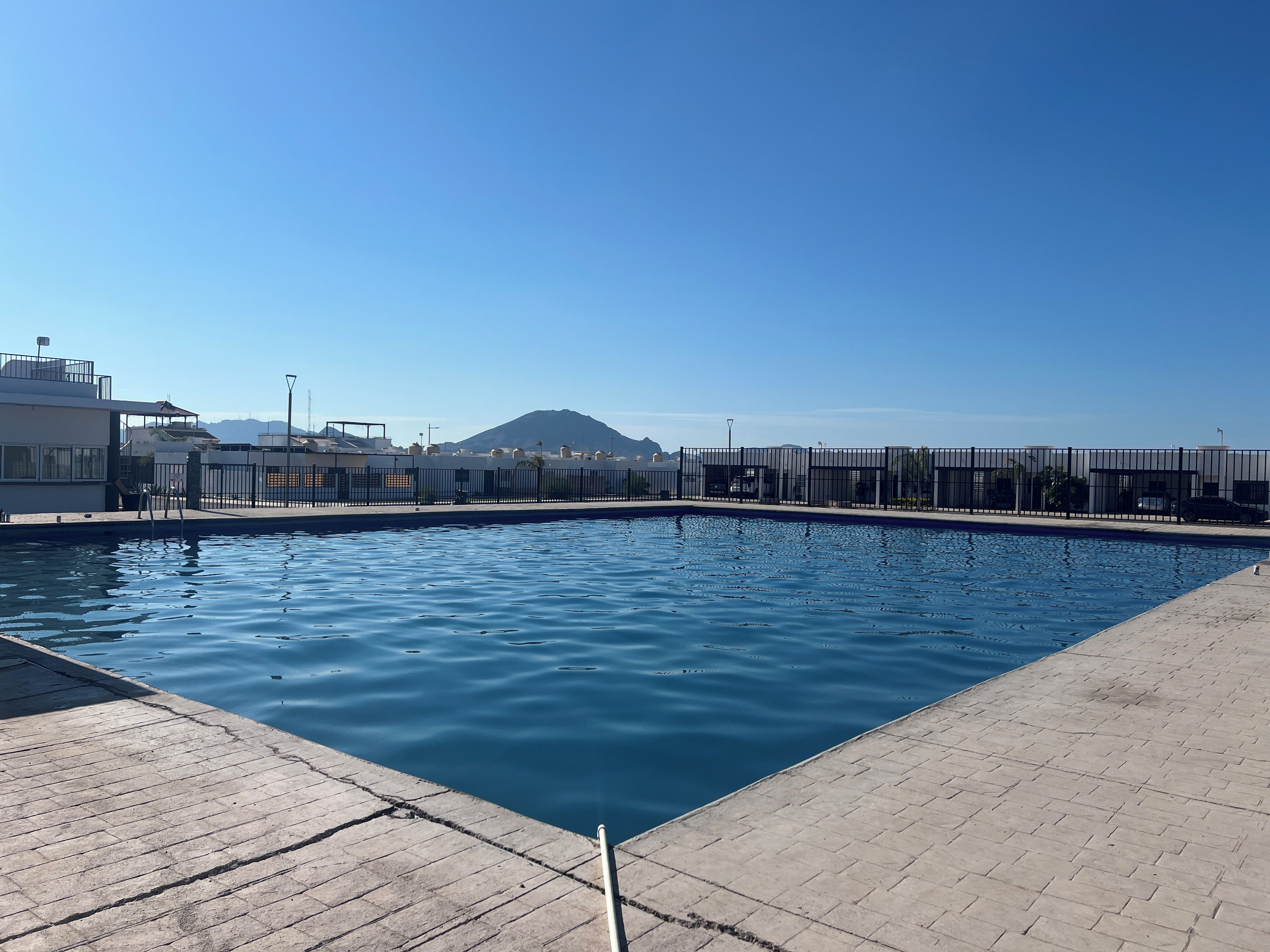 Ein Swimmingpool mit freiem Blick auf Gebäude und einen Berg im Hintergrund.