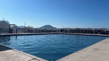 Ein Swimmingpool mit freiem Blick auf Gebäude und einen Berg im Hintergrund.