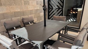 Un comedor con una mesa rectangular y cuatro sillas, cada una con asiento y respaldo acolchados.