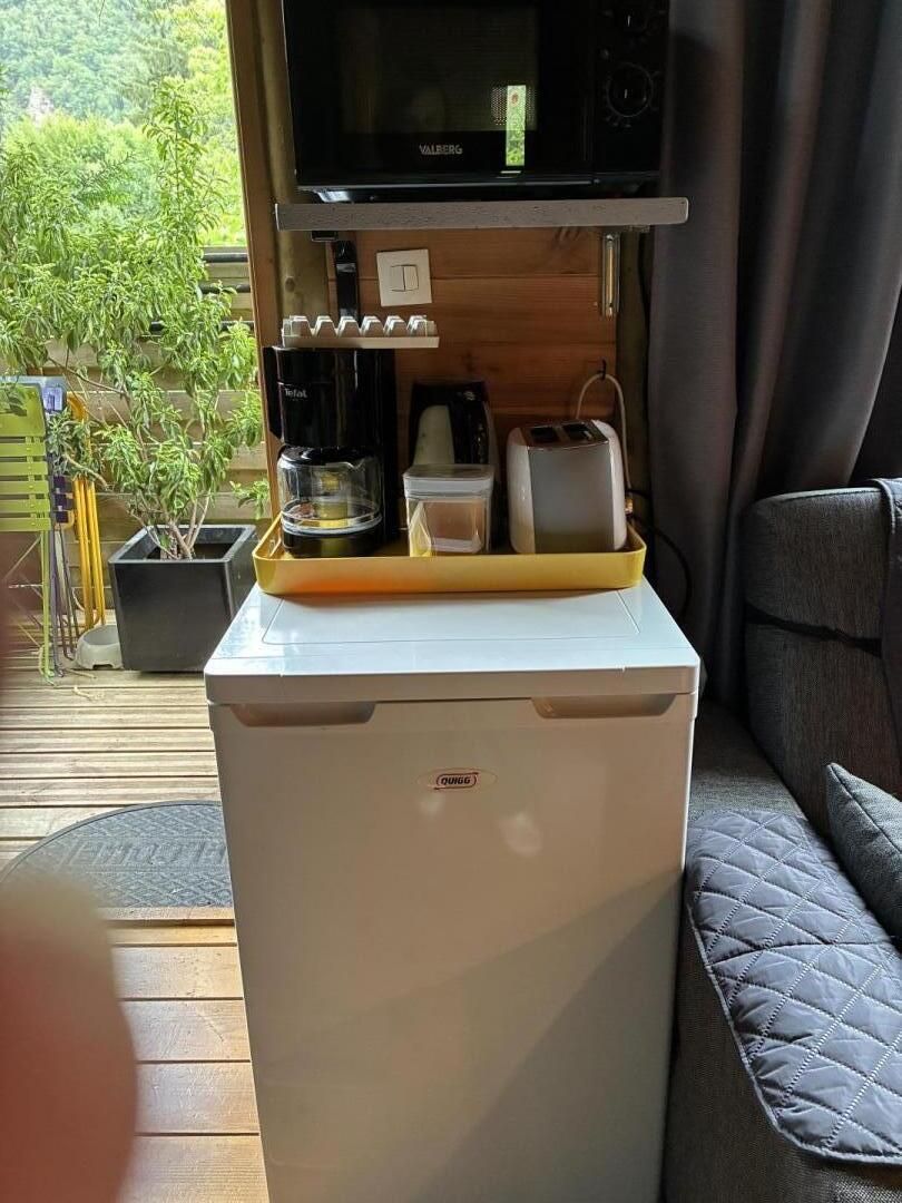 Eine kleine Küchenzeile mit Mikrowelle, Kaffeemaschine und Toaster.
