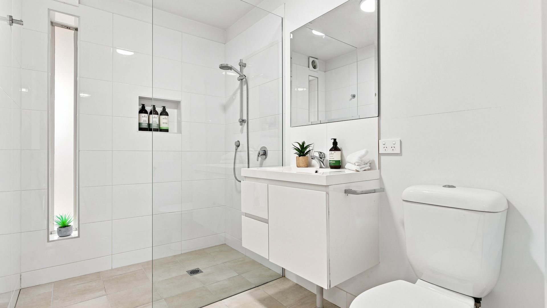 Une salle de bain moderne équipée d’une douche, de toilettes et d’un lavabo.