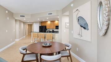 A dining area with a round table, four chairs, and a wall-mounted artwork of a bird.