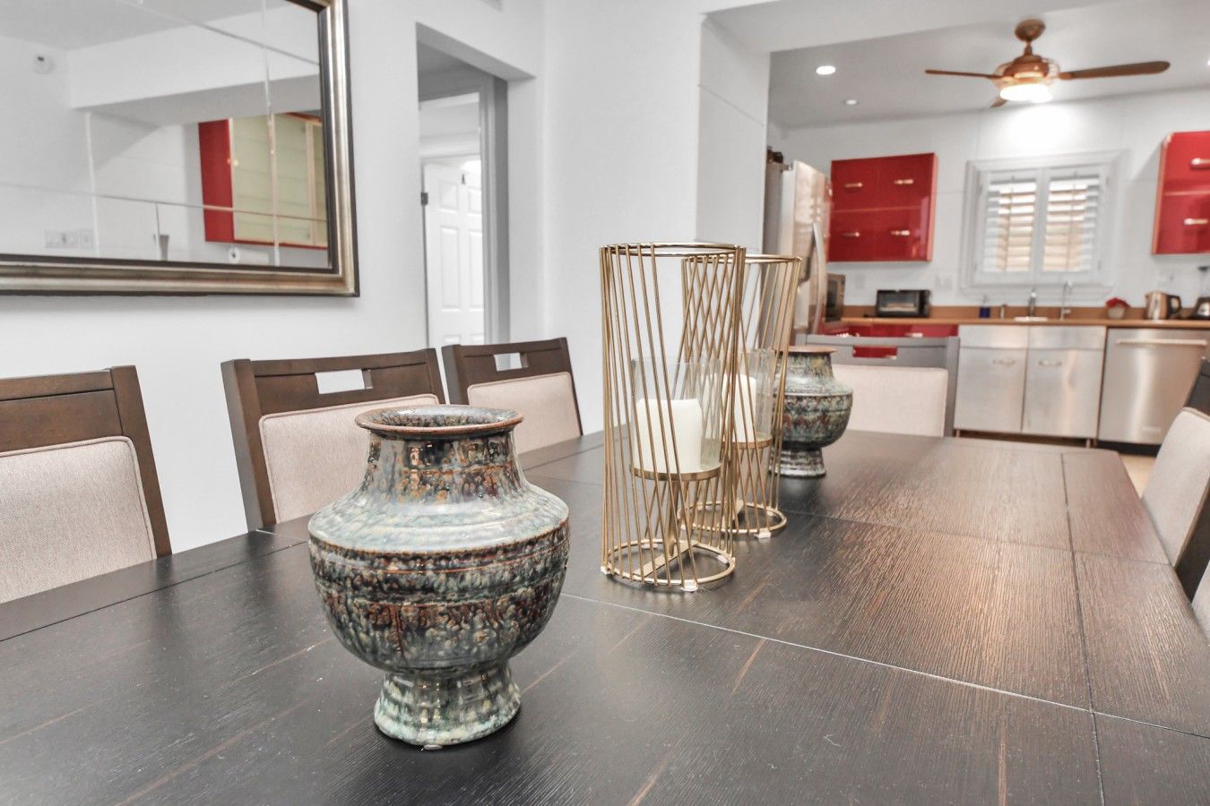 Una mesa de comedor con un jarrón decorativo y candelabros.