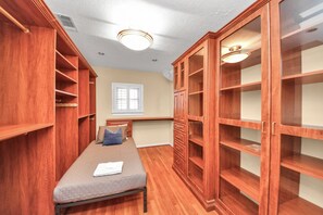 Una habitación con cama, estanterías de madera y ventana.